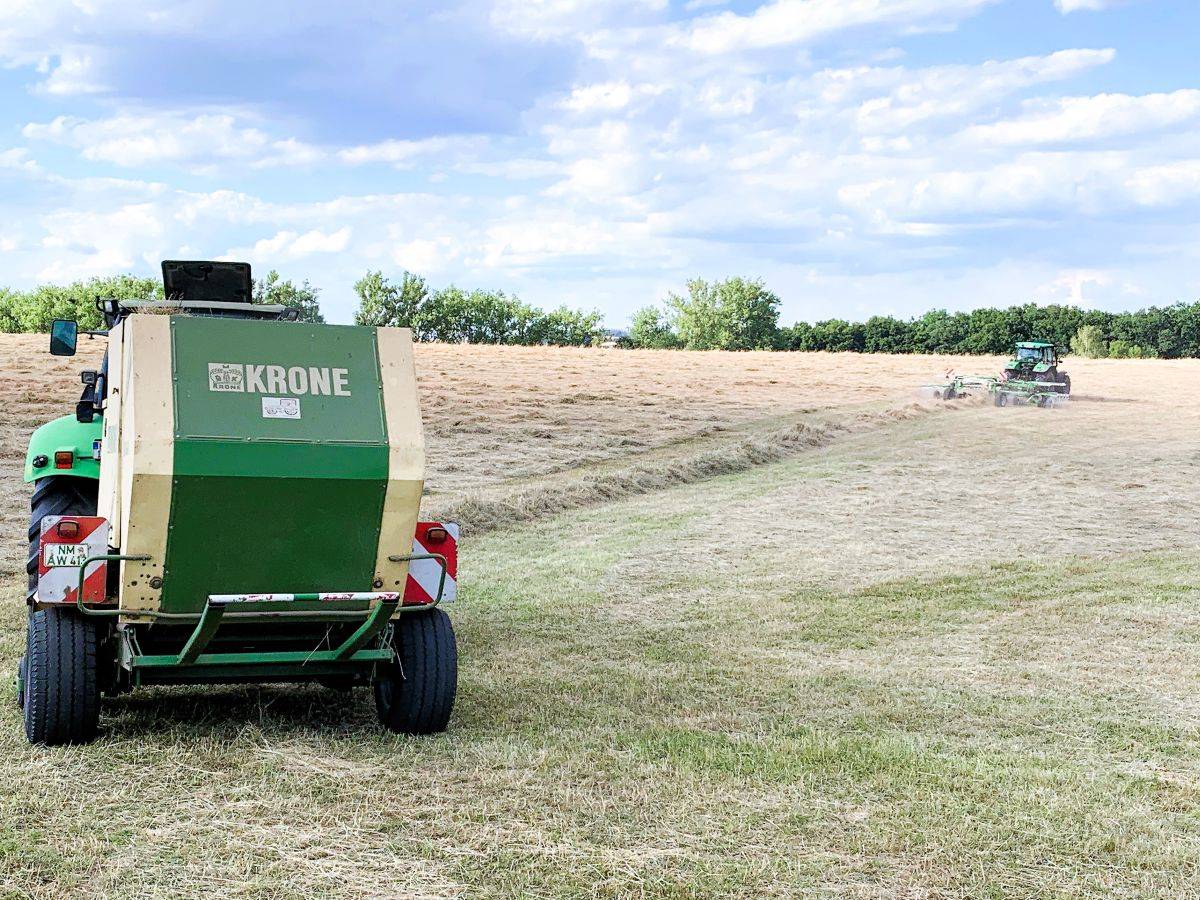 Traktoren beim Schwarten und Pressen von Heu auf Gestüt Gut Buchenhof